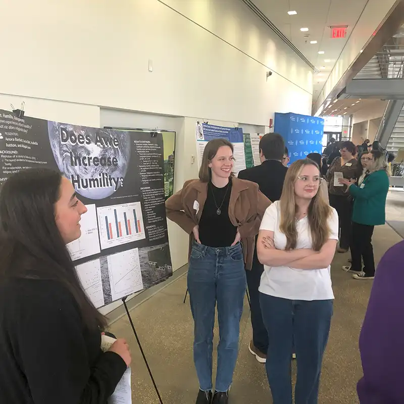 ���Ͽ� Students presenting poster at conference.