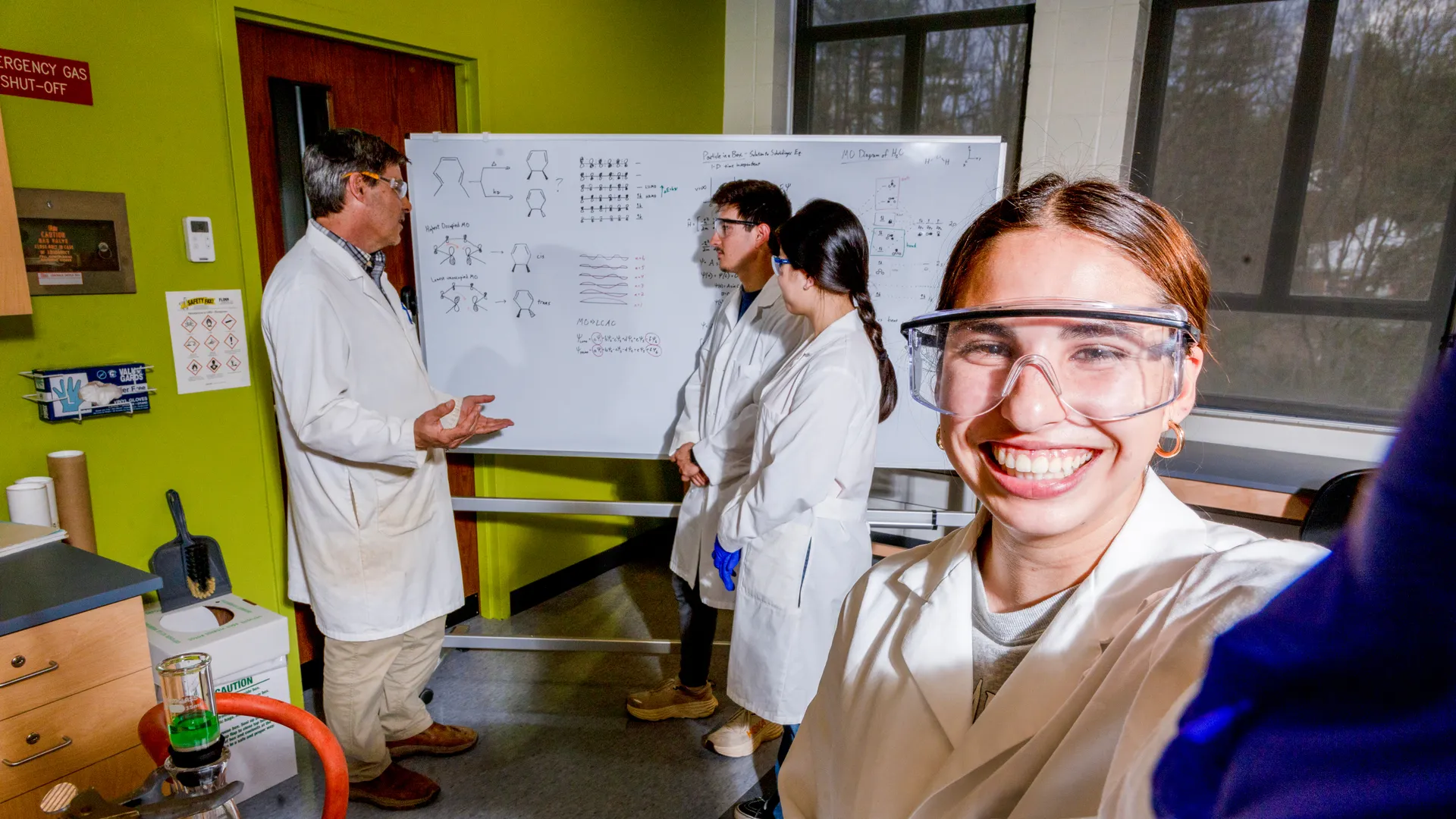 Student taking a selfie in the chemistry lab with professors