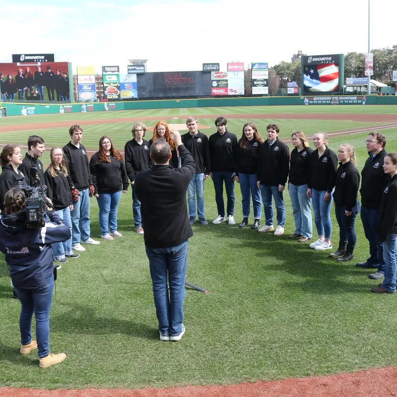 Chamber Choir performance on a baseball field