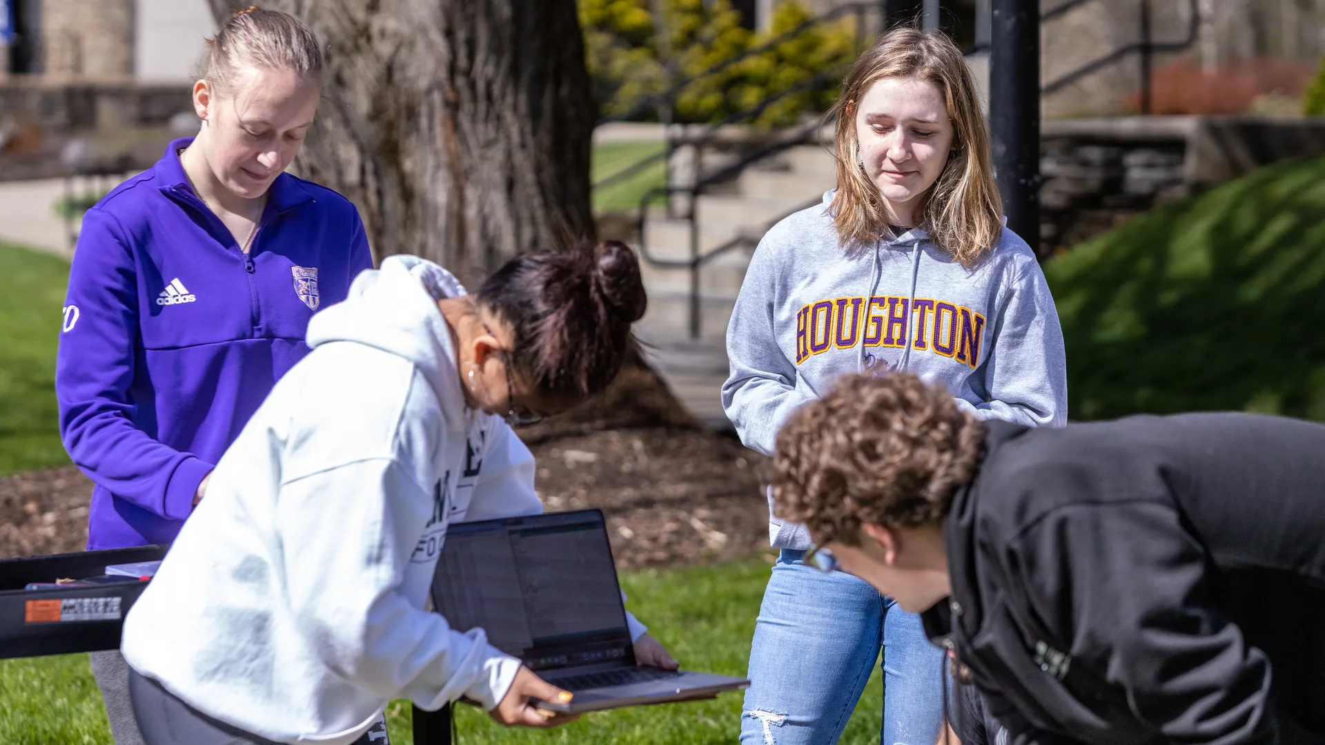 Students outside looking at the computer